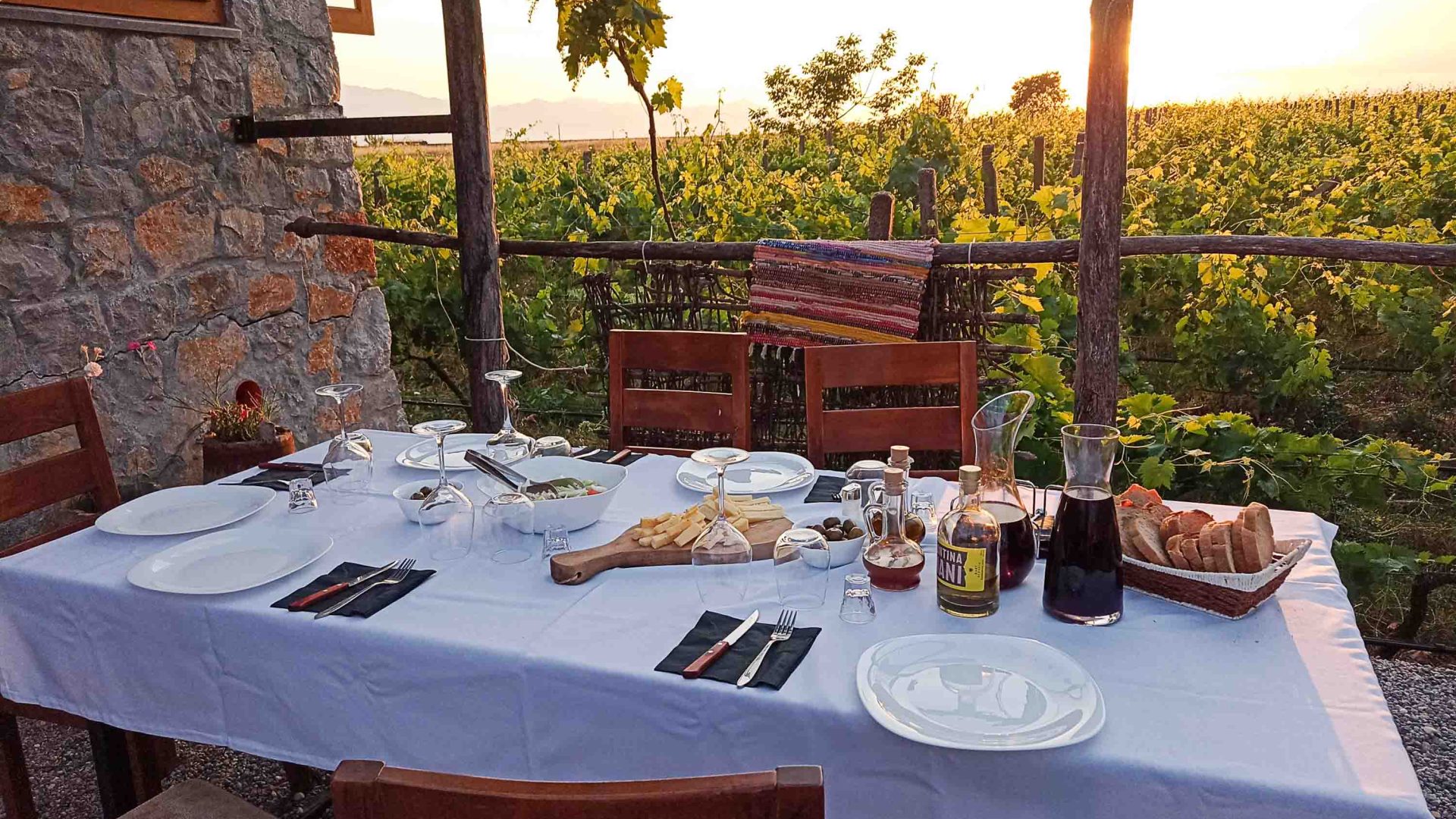 A table laid out with wine and appetisers overlooking the vineyards.