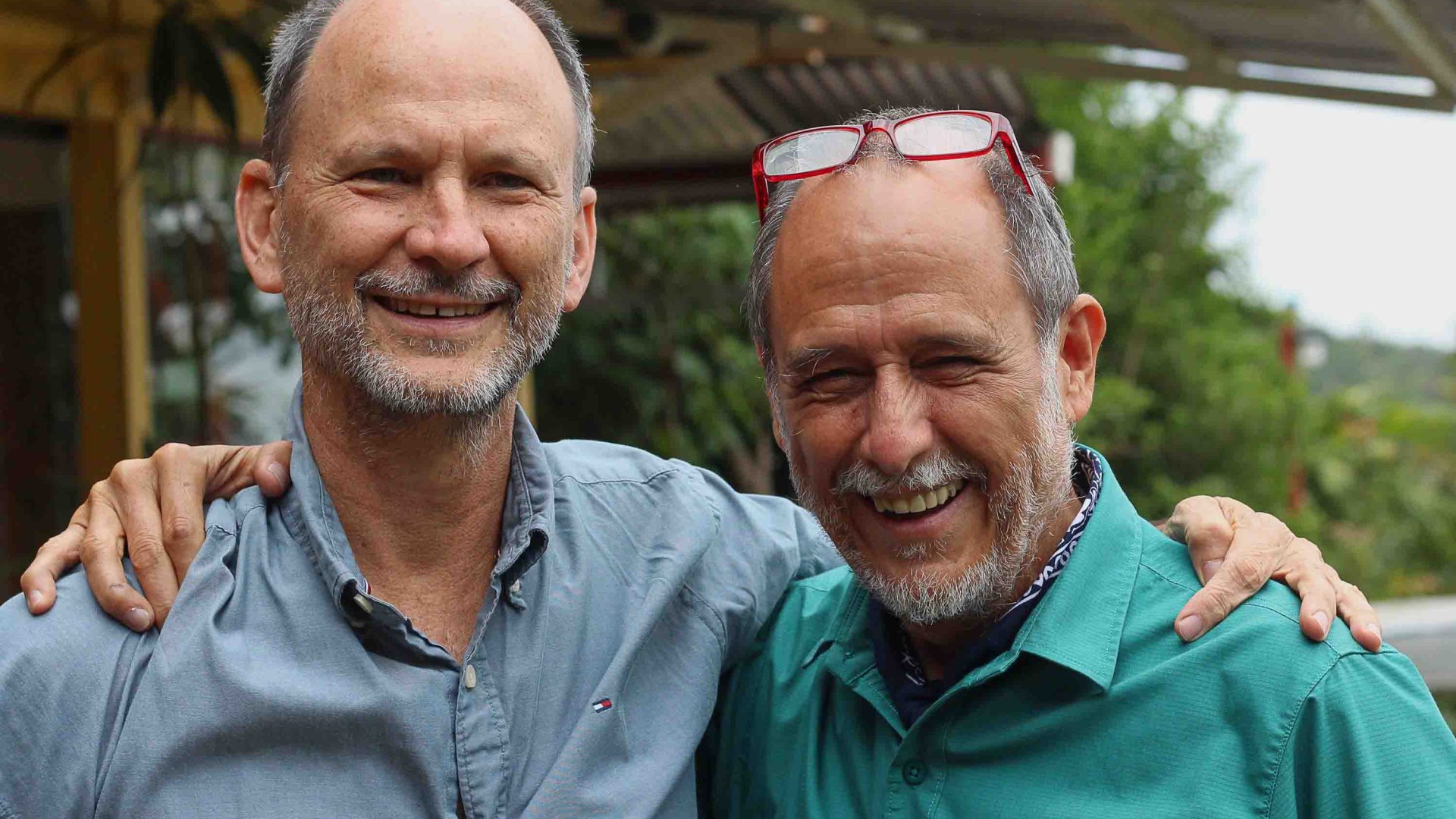 Two men smile to camera.