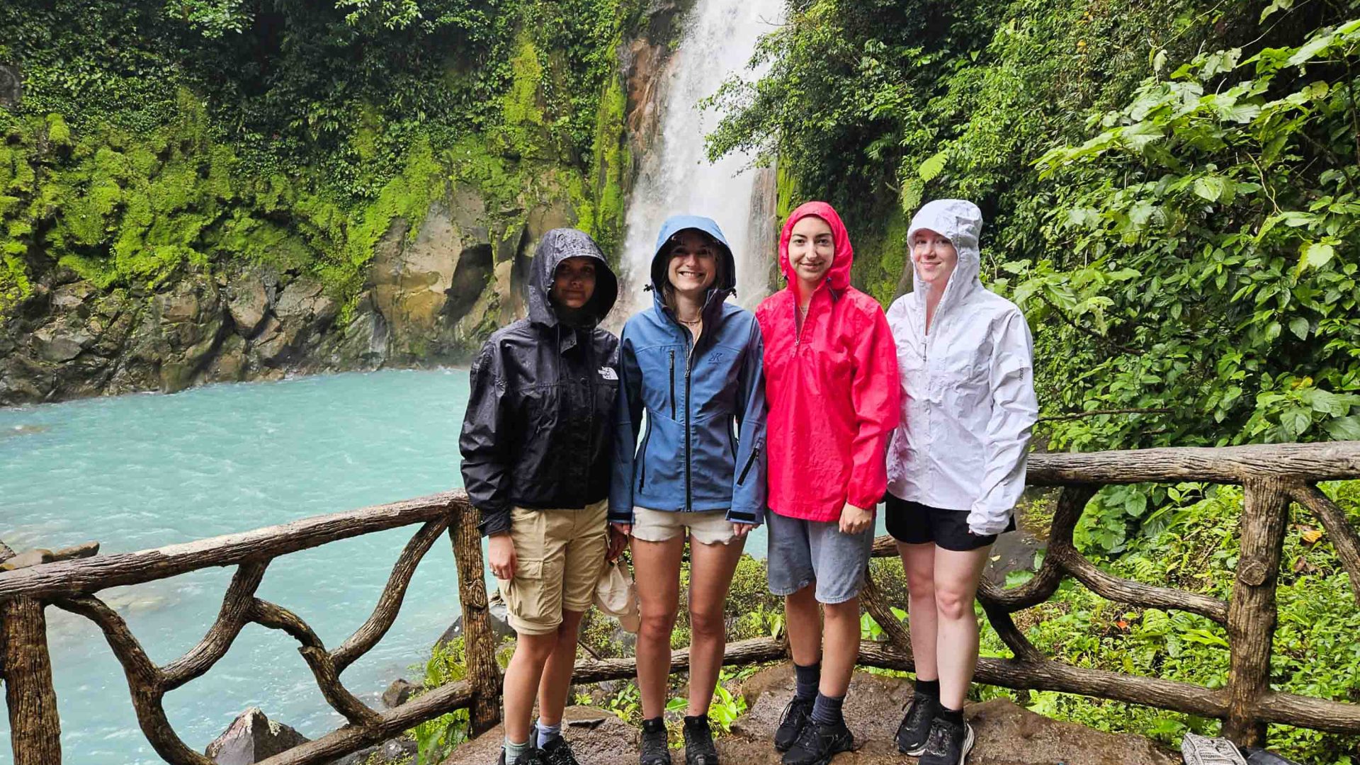 The group stands in front of a waterfall.