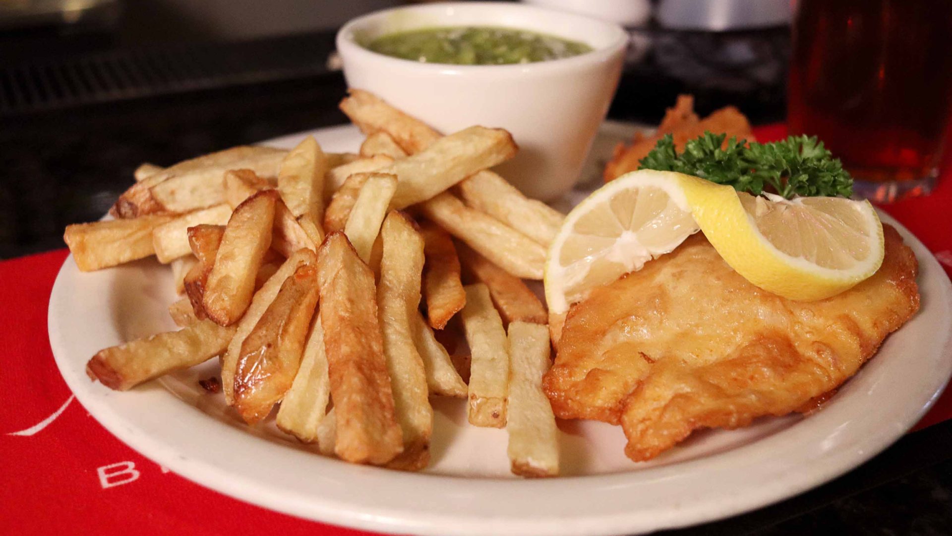 A meal of fish, chips and peas.