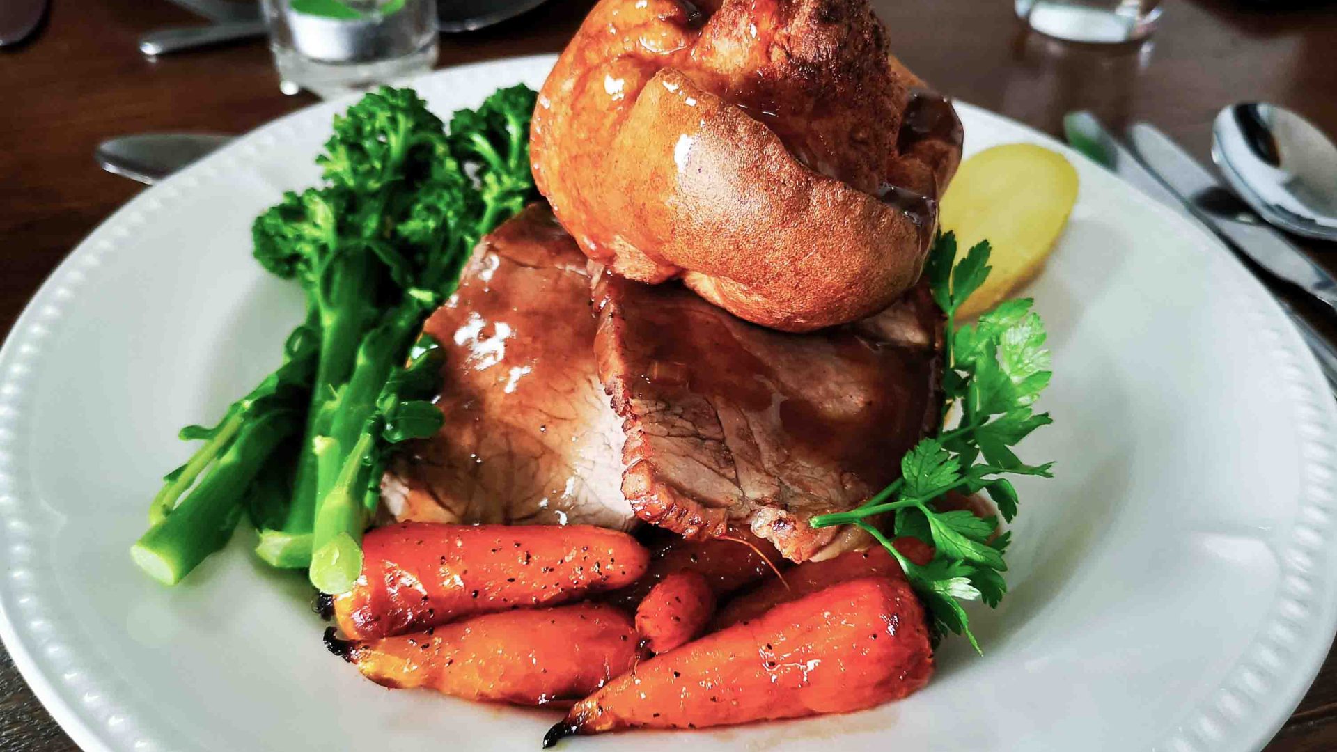 A roast dinner with a Yorkshire pudding on the top of it.