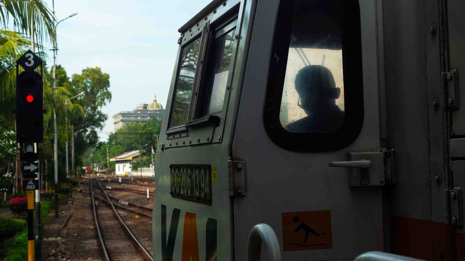 The front carriage of the train waiting at the station. The silhouette of the driver is visible.