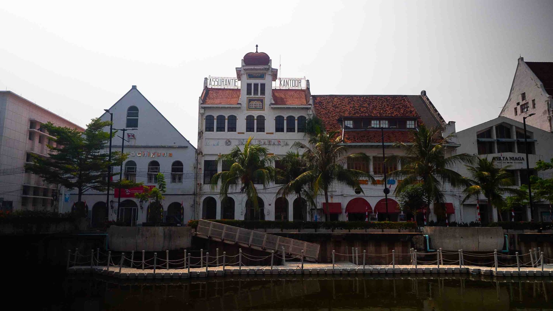 Old buildings run the length of a river.