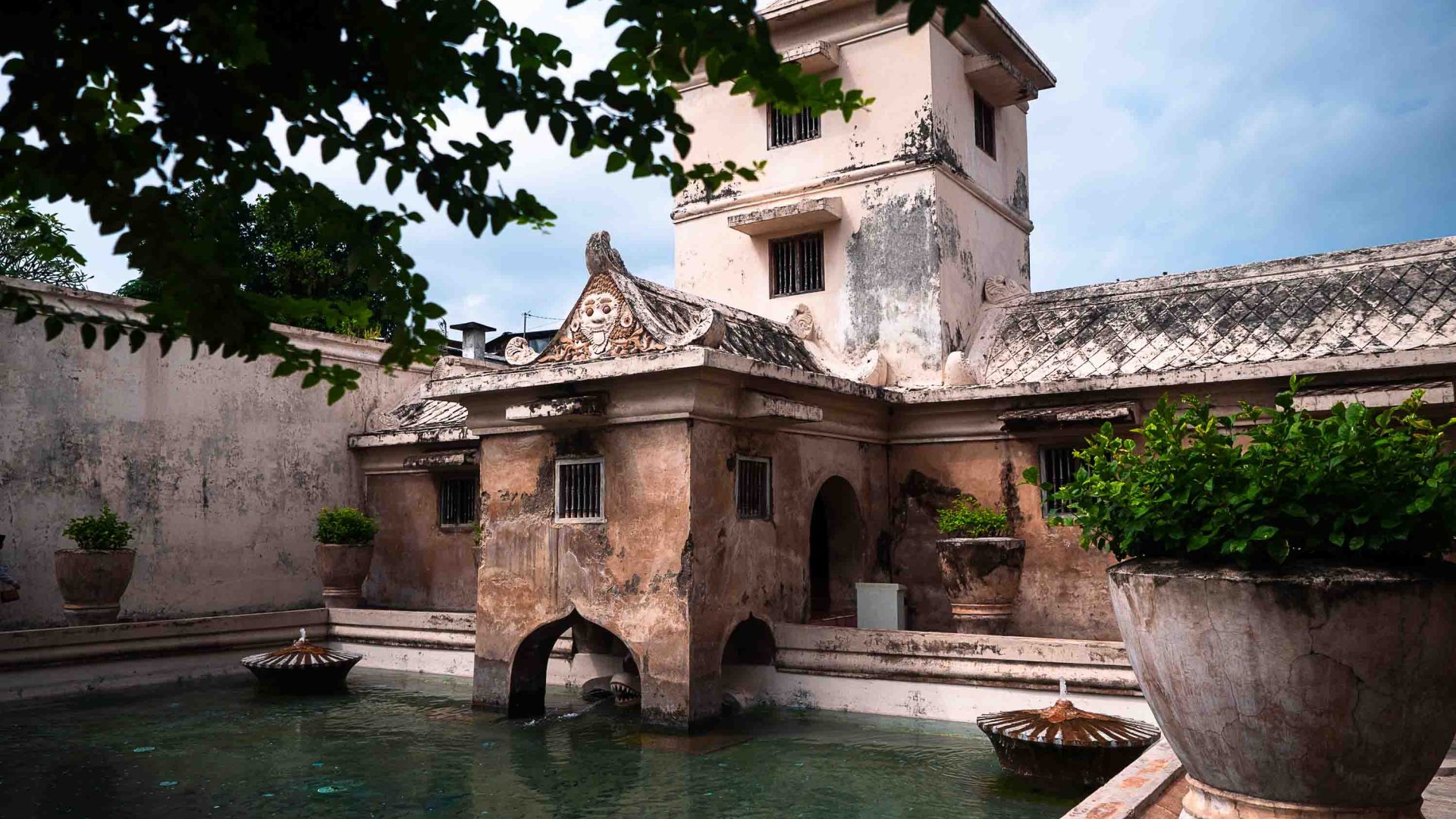 A palace on the edge of a pool of green water.