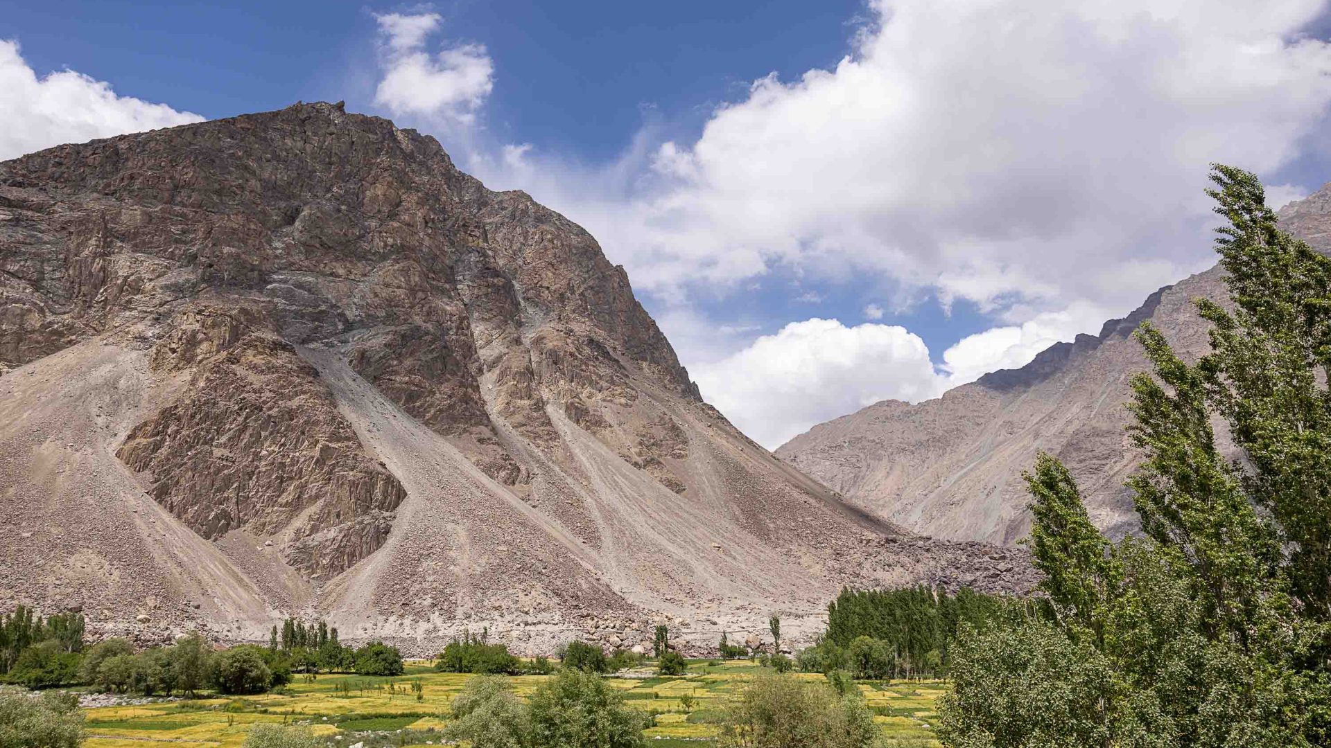 Barren mountains with a green valley at the base.