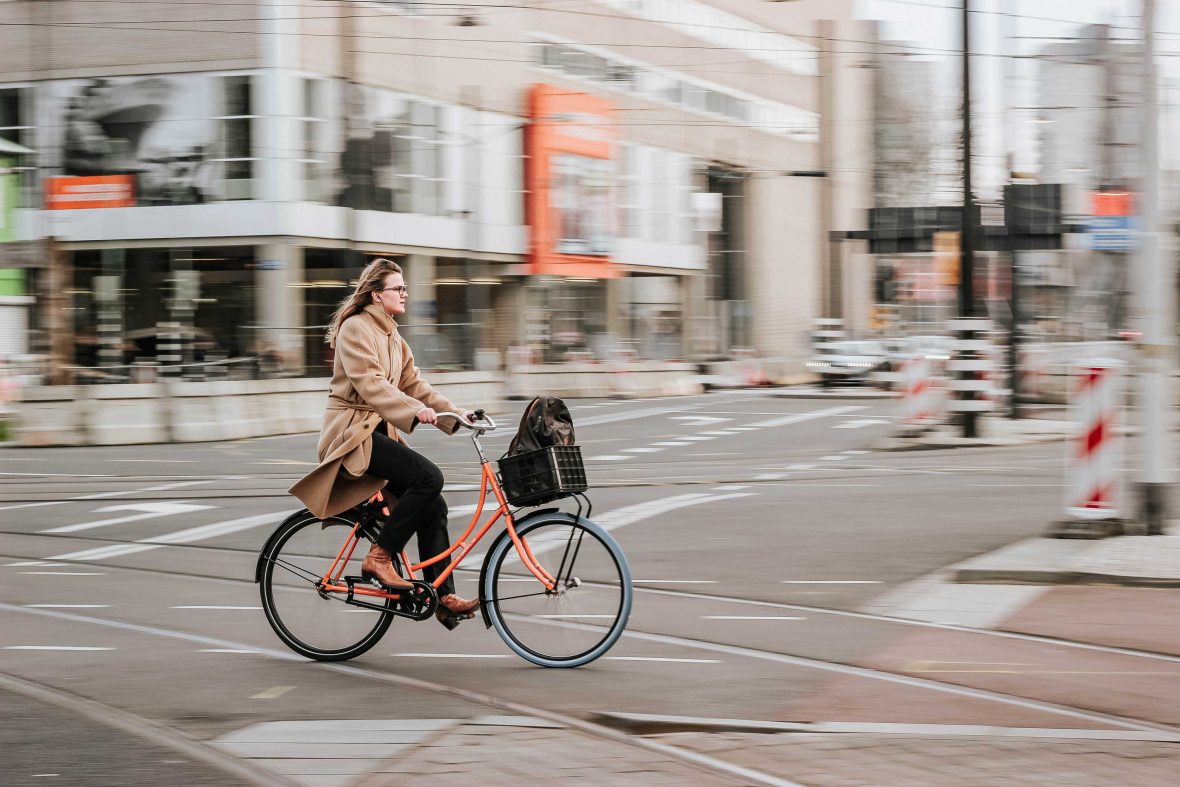 A woman rides her bike in the street.