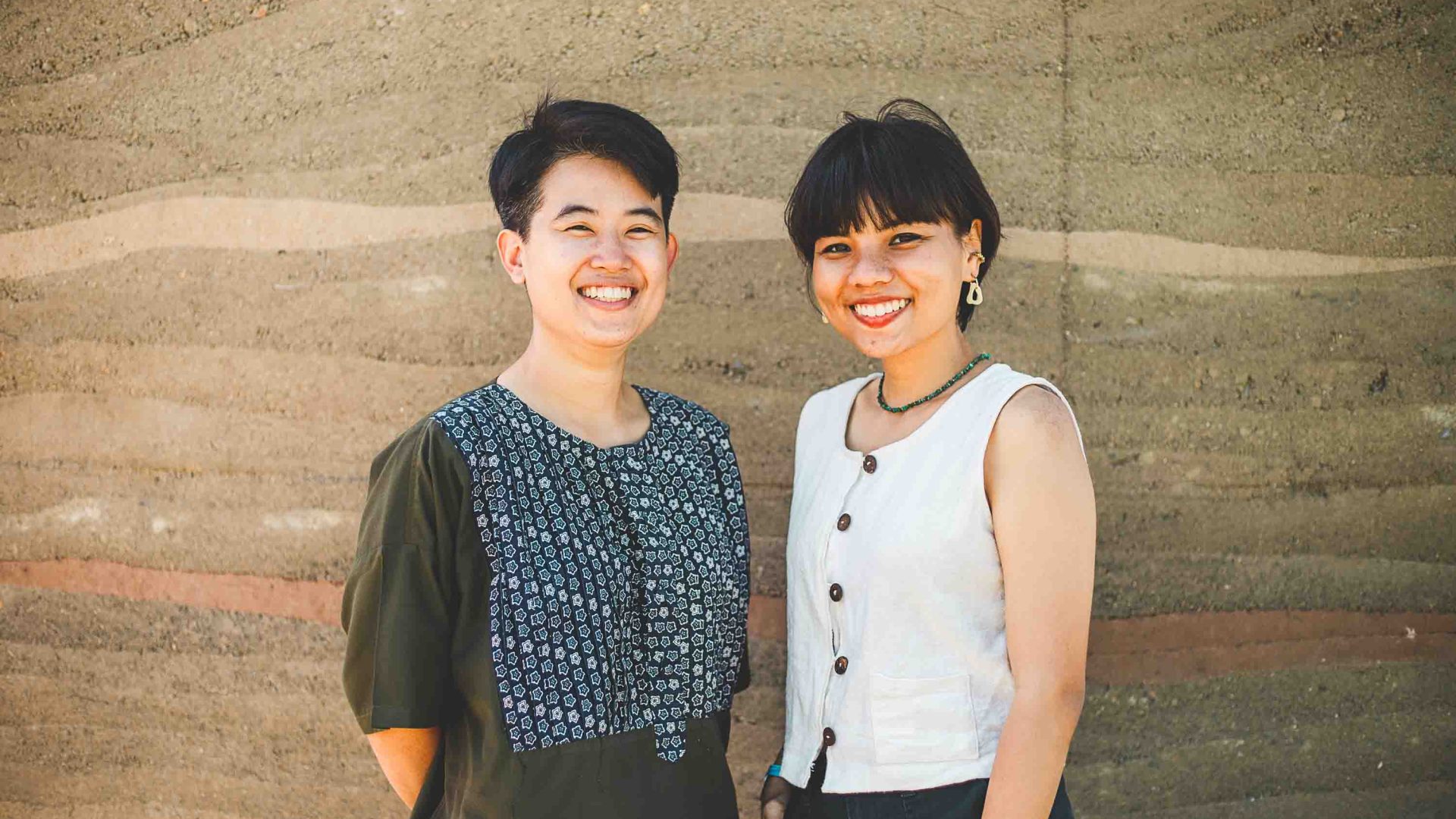 Two women smile for a portrait together.