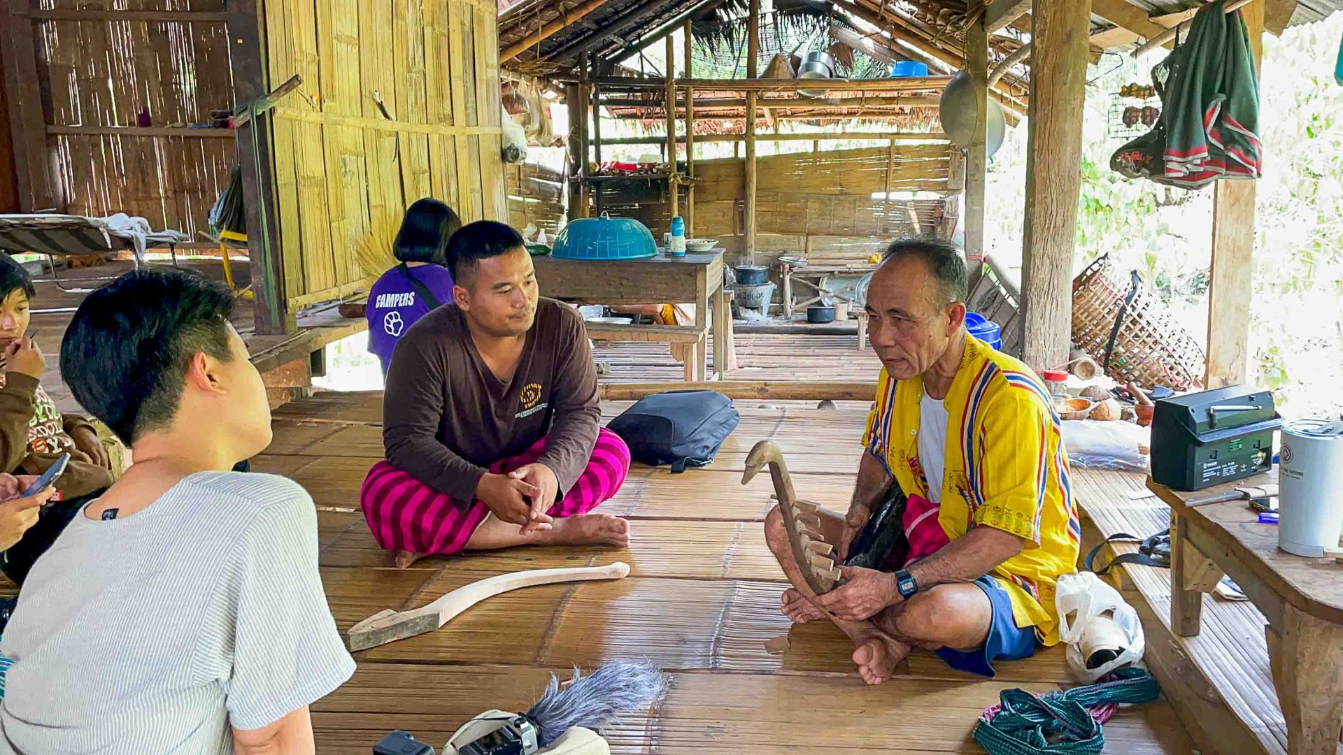 Indigenous musicians being recorded for Hear & Found. They sit on a wooden floor.