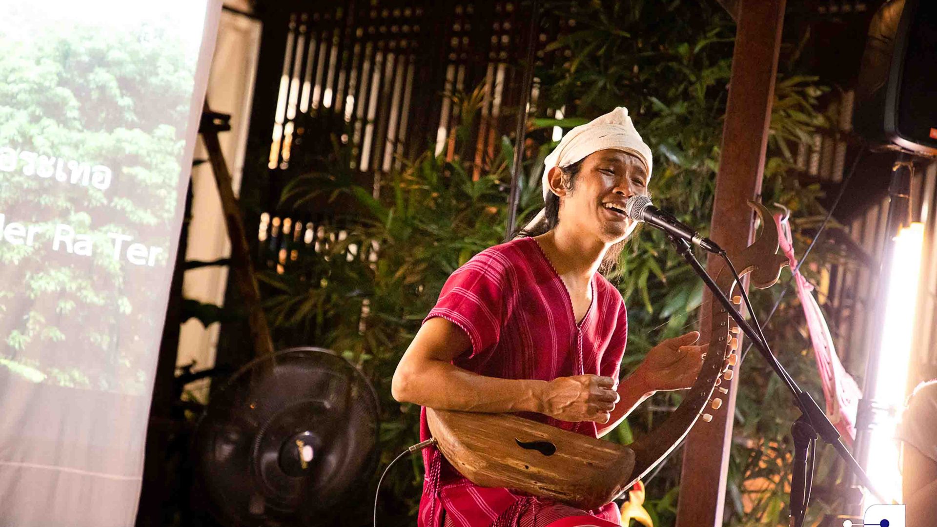 An Indigenous musician sings and performs with an instrument.