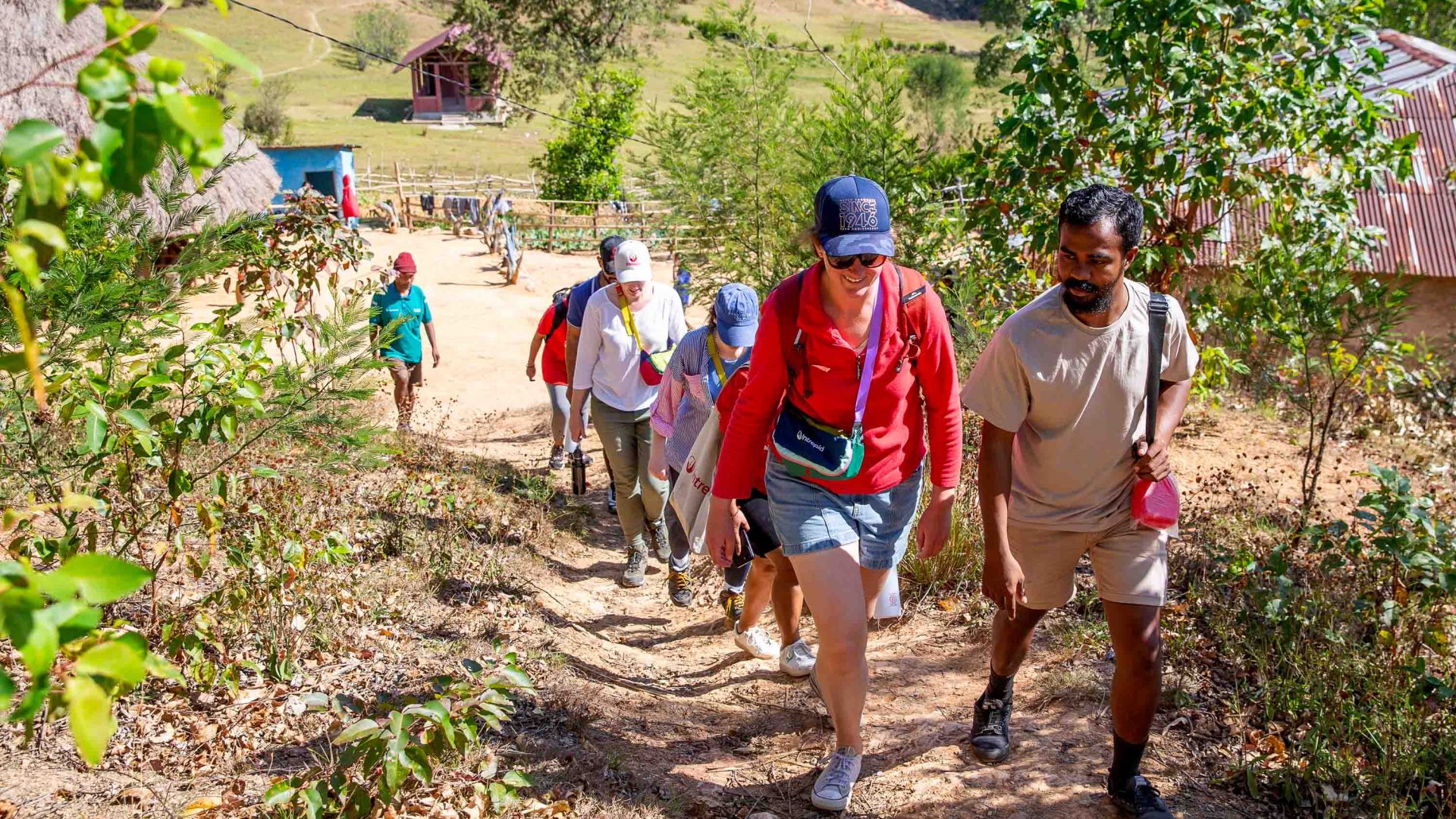 Intrepid tour participants walk up a hill.