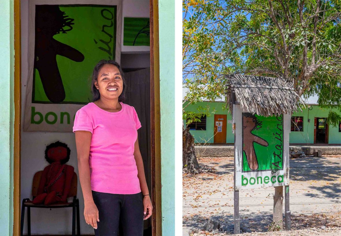 A woman stands at a green doorway smiling.