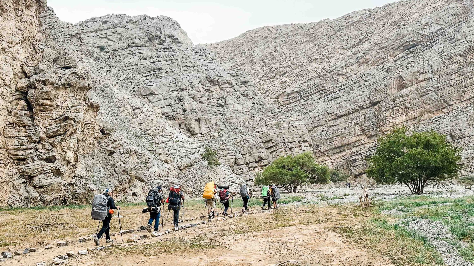 A group walks in single file along a trail.